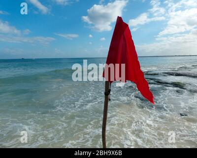 Eine rote Flagge, die vom Rettungsschwimmer angebracht wird, weist auf eine Gefahr hin. Keine Schwimmer dürfen ins Wasser. Stockfoto