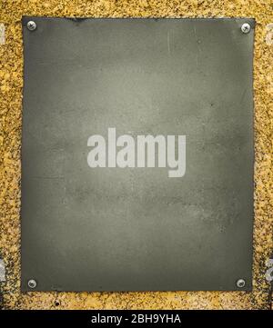 Alte geschraubte Plakette an der Steinwand Stockfoto