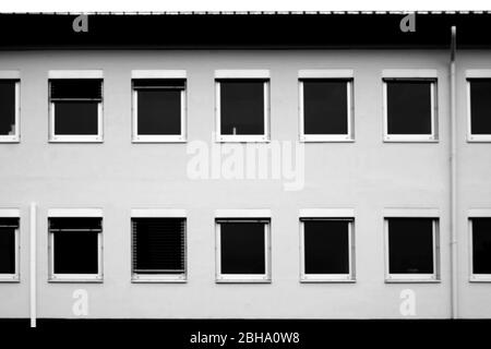 Die einfache Windows eines Bürogebäudes mit schwarzen Jalousien. Stockfoto
