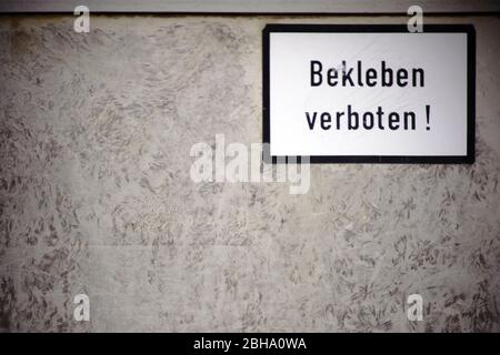 Der Nahaufnahme einer Anschlagtafel mit abgerissene Papierreste von Plakaten und Leimreste und ein Warnschild: ohne zu kleben. Stockfoto