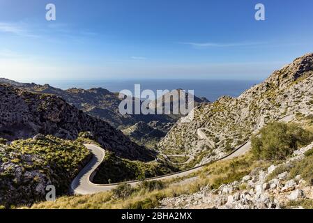 Blick auf die Serpentinenstraße mit ihren vielen Kurven im felsigen Tramuntana-Gebirge auf Mallorca von oben, im Hintergrund das Mittelmeer Stockfoto