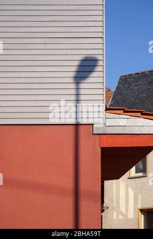 Eine Laterne Schatten auf einem Braunen glänzenden Fassade mit Holz Dekoration. Stockfoto