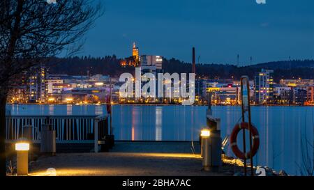 Die Stadt Jyväskylä in Finnland liegt zwischen dem Jyväsjärvi-See und einem Harju-Grat. Die beleuchtete Skyline ist spektakulär. Stockfoto