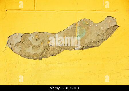 Gelbe Wand mit Kratzern und Spänen. Abstrakter Hintergrund. Stockfoto