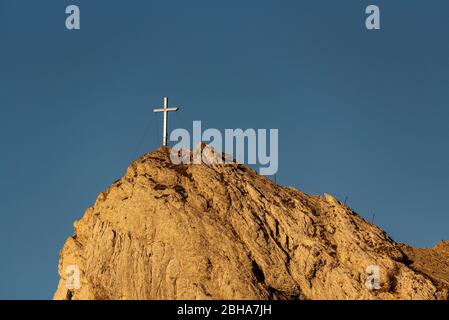 Das Gipfelkreuz der westlichen Karwendelspitze oberhalb von Mittenwald gegen blauen Himmel Stockfoto