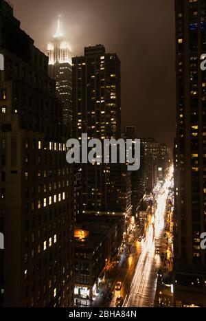 Blick auf die 6th Avenue bei Nacht in New York City. Stockfoto