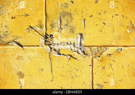 Gelbe Wand mit Kratzern und Spänen. Abstrakter Hintergrund. Stockfoto