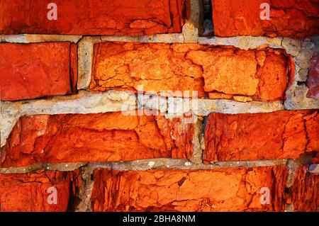 Mauer aus rotem Backstein Nahaufnahme ruiniert. Abstrakter Hintergrund. Stockfoto