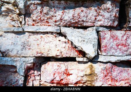 Mauer aus rotem Backstein Nahaufnahme ruiniert. Abstrakter Hintergrund. Stockfoto