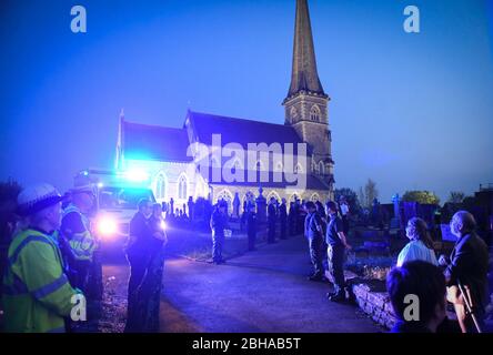 Swansea, Wales, Großbritannien. April 2020. Die Mitarbeiter des Rettungsdienstes stehen zu Ehren in einer Wache, die von einer Flut von blauem Licht aus ihren Fahrzeugen überflutet wird, während eines Gedenkens für den Rettungsdienst Gerallt Davies, der letzte Woche an Covid-19 gestorben ist. Die Mitarbeiter, viele, die mit Gerallt arbeiteten, wurden mit Mitgliedern seiner Gemeinde aus dem Dorf Pontadardawe in der Nähe von Swansea verbunden. Er war das erste Mitglied des Welsh Ambulance Services NHS Trust, das mit Covid-19 starb, so sein Chief Executive. Quelle : Robert Melen/Alamy Live News. Stockfoto