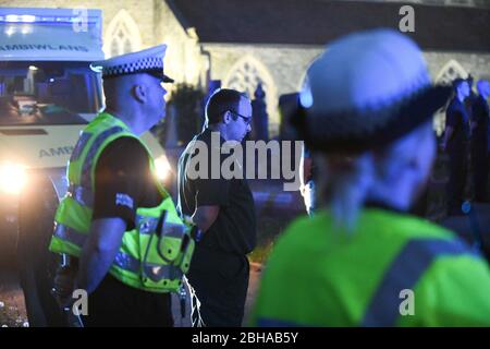 Swansea, Wales, Großbritannien. April 2020. Die Mitarbeiter des Rettungsdienstes stehen zu Ehren in einer Wache, die von einer Flut von blauem Licht aus ihren Fahrzeugen überflutet wird, während eines Gedenkens für den Rettungsdienst Gerallt Davies, der letzte Woche an Covid-19 gestorben ist. Die Mitarbeiter, viele, die mit Gerallt arbeiteten, wurden mit Mitgliedern seiner Gemeinde aus dem Dorf Pontadardawe in der Nähe von Swansea verbunden. Er war das erste Mitglied des Welsh Ambulance Services NHS Trust, das mit Covid-19 starb, so sein Chief Executive. Quelle : Robert Melen/Alamy Live News. Stockfoto