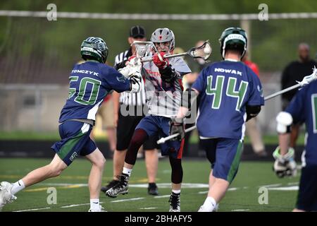 Zwei Verteidiger schließen sich einem Gegner, als er während eines High School Lacrosse Spiels versuchte, einen Schuss auf das Tor zu bekommen. USA. Stockfoto