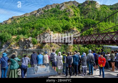 Touristen beobachten Bungy, die von der Hängebrücke der Kawarau Gorge in der Nähe von Queenstown, Otago, Neuseeland, springen. Stockfoto