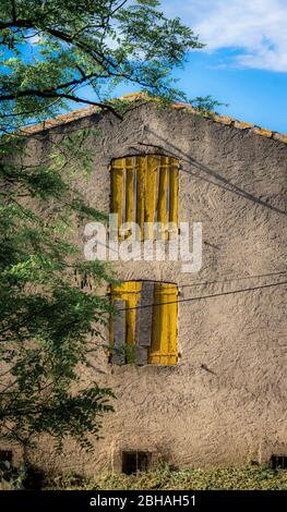 Altes Haus mit gelben Fensterläden in Montady bei Beziers Stockfoto