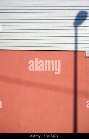 Eine Laterne Schatten auf einem Braunen glänzenden Fassade mit Holz Dekoration. Stockfoto