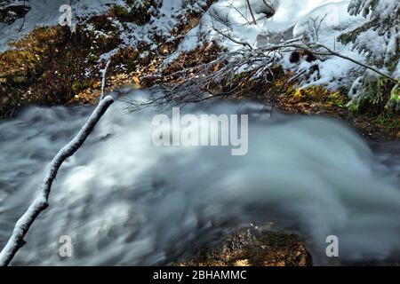 Laintalbach (Bach) in der Schneeschmelze mit starkem Wasserfluss Stockfoto