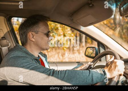 Happy man in Sonnenbrillen Fahren EIN Auto Stockfoto