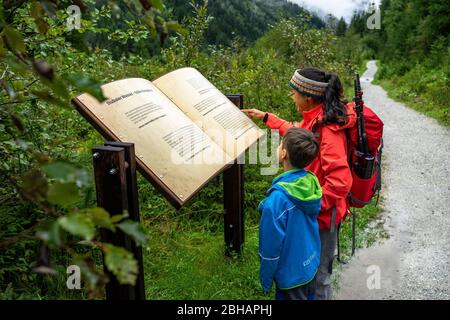 Europa, Österreich, Tirol, Neustift im Stubaital, Mutter zeigt ihrem Sohn eine Informationstafel auf dem Wilden Wasser-Weg im Stubaital Stockfoto