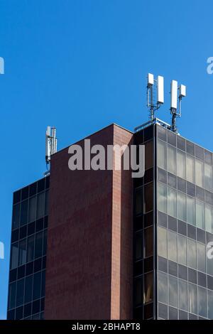 Ein moderner Büroblock mit 5G-Antennen auf der Oberseite Es für Mobiltelefone oder Handy-Empfang Stockfoto