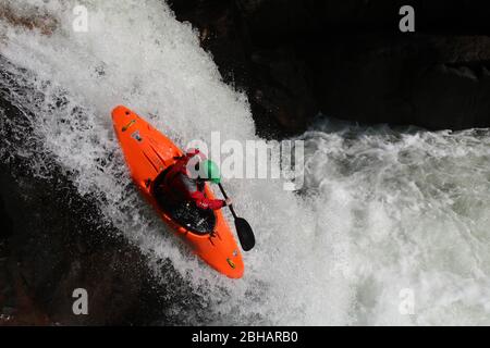 Frau Wildwasser Kajak vor dem rechten Winkel Wasserfall auf dem Etive River, Glen Coe, schottische Highlands, Schottland, Großbritannien Stockfoto