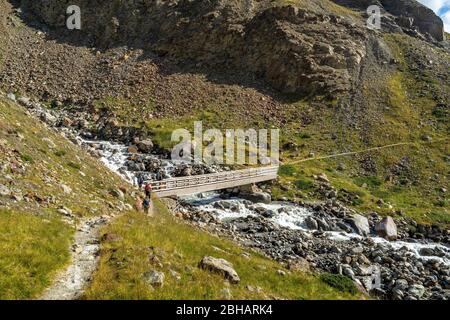 Europa, Österreich, Tirol, Ötztaler Alpen, Vent, Bergsteiger überqueren Brücke in Abstieg durch das Rofental nach Vent Stockfoto