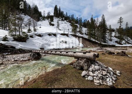 Eine Holzbrücke über einen kleinen Bergbach, die Isar im Karwendel Stockfoto