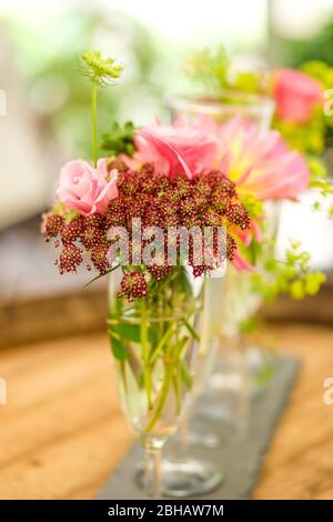 Blumenarrangement auf einem Holzfass Stockfoto