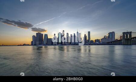 Silhouette von Downtown Manhattan mit Brooklyn Bridge vom Brooklyn Bridge Park über den East River bis zum Sonnenuntergang Stockfoto