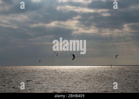 Deutschland, Niedersachsen, Ostfriesland, Norddeich, Kitesurfer vor Norddeich. Stockfoto