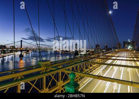 Lange Belichtung über der Brooklyn Bridge Road und dem East River mit Manhattan Bridge bei Sonnenaufgang Stockfoto