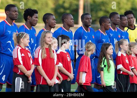 Austin, Texas USA, 28. April 2010: Schüler stehen mit Mitgliedern der haitianischen Fußballnationalmannschaft bei einem Ausstellungsspiel mit der professionellen Fußballmannschaft Austin Aztek. Das Haitianer-Werk in Port au Prince wurde durch das Erdbeben vom 12.. Januar dezimiert und 32 Teammitglieder wurden getötet. Die überlebenden Teammitglieder haben ein Angebot angenommen, für zwei Wochen in Texas zu trainieren und werden nächste Woche nach Argentinien reisen, um Südamerikanische Matchups zu machen. ©Bob Daemmrich Stockfoto