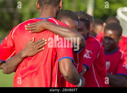 Austin, Texas, USA, 28. April 2010: Mitglieder der haitianischen Fußballnationalmannschaft umarmen sich vor einem Ausstellungsspiel mit der professionellen Fußballmannschaft Austin Aztek. Das Haitianer-Werk in Port au Prince wurde durch das Erdbeben vom 12.. Januar dezimiert und 32 Teammitglieder wurden getötet. Die überlebenden Teammitglieder haben ein Angebot angenommen, für zwei Wochen in Texas zu trainieren und werden nächste Woche nach Argentinien reisen, um Südamerikanische Matchups zu machen. ©Bob Daemmrich Stockfoto