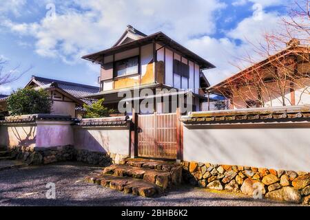 Historisches Wohnhaus in traditioneller japanischer Architektur, umgeben von weißer Wand mit Holztor im abgelegenen Dorf Ohara. Stockfoto