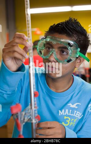 Carrollton Texas USA, Mai 2010: Ein Schüler mit Schutzbrille arbeitet an einem Experiment während eines Chemielabors an der METSA (Math Engineering Technology Science Academy), einer öffentlichen High School, die MINT-Kurse in einem projektbasierten Lernplan betont. ©Bob Daemmrich Stockfoto