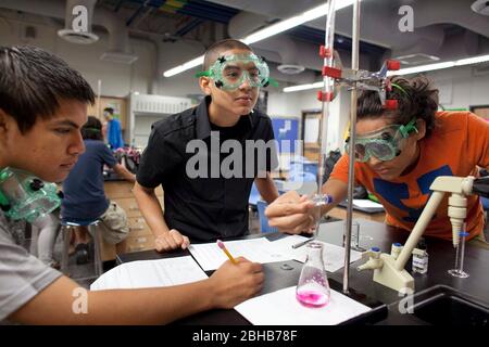 Carrollton Texas USA, Mai 2010: Schüler mit Schutzbrillen arbeiten während des Chemielabors an einem Experiment an der METSA (Math Engineering Technology Science Academy), einer öffentlichen High School, die MINT-Kurse in einem projektbasierten Lernplan betont. ©Bob Daemmrich Stockfoto