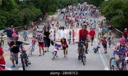 Austin Texas USA, 4 2010. Juli: Fußgänger mischen sich mit Erwachsenen und Kindern auf Fahrrädern während der jährlichen Parade der Gemeinde am 4. Juli durch das grüne Wohnviertel. ©Bob Daemmrich Stockfoto