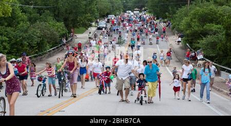 Austin Texas USA, 4 2010. Juli: Fußgänger mischen sich mit Erwachsenen und Kindern auf Fahrrädern während der jährlichen Parade der Gemeinde am 4. Juli durch das grüne Wohnviertel. ©Bob Daemmrich Stockfoto