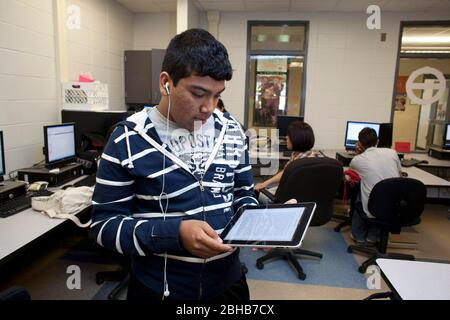 Manor Texas USA, Mai 12 2010: Teenager liest Text auf einem Apple iPad Tablet-Computer, während sie im Computerlabor der Manor New Tech High School, einer innovativen öffentlichen Schule, die sich auf projektbasiertes Lernen im Lehrplan TSTEM (Technology Science Engineering Mathematics) konzentriert. ©Bob Daemmrich Stockfoto