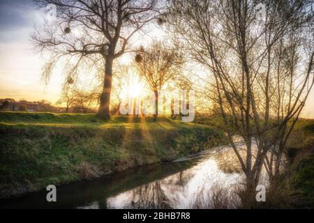 Sonnenuntergang auf einem Fluss mit reflektierender Wasseroberfläche Stockfoto