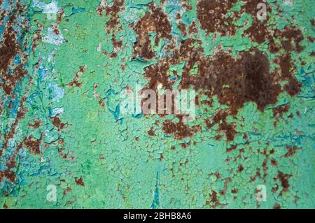 Metall mit grüner Farbe bemalt, von der aus man den Rost aus nächster Nähe sehen kann. Textur, Hintergrund Stockfoto