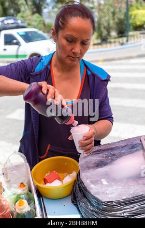 San Jose de Minas, Pichincha, Ecuador, 10. August 2019: Nachbardorf Frau bereitet und verkauft aromatisierte Slushies, im zentralen Park zu denen w Stockfoto