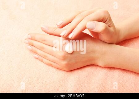 Frau Pflege Hände mit Creme auf Stoff Hintergrund Stockfoto