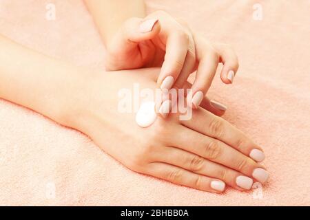 Frau Pflege Hände mit Creme auf Stoff Hintergrund Stockfoto