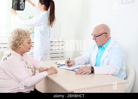 Glückliche Ärzte und Patienten in der Klinik Stockfoto