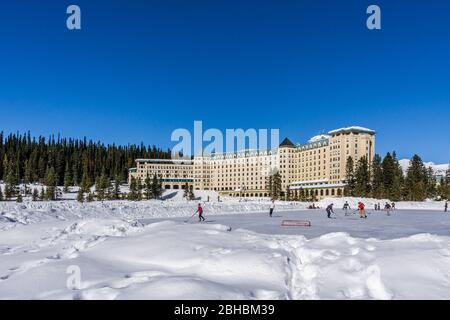 LAKE LOUISE, KANADA - 20. MÄRZ 2020: Hockey vor dem fairmont Chateau und dem gefrorenen Lake louise Frühlingszeit. Stockfoto