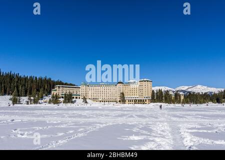 LAKE LOUISE, KANADA - 20. MÄRZ 2020: fairmont Chateau und gefrorener Lake louise Frühlingszeit. Stockfoto