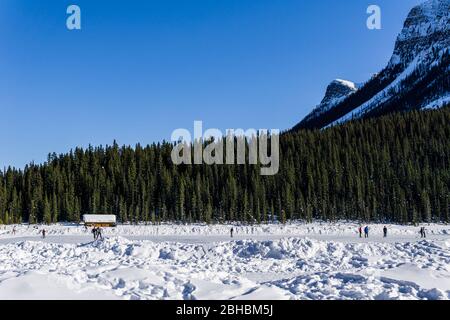 LAKE LOUISE, KANADA - 20. MÄRZ 2020: Felsige Berge rund um den gefrorenen Lake louise Winterwunderland. Stockfoto