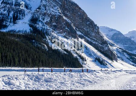 LAKE LOUISE, KANADA - 20. MÄRZ 2020: Felsige Berge rund um den gefrorenen Lake louise Winterwunderland. Stockfoto