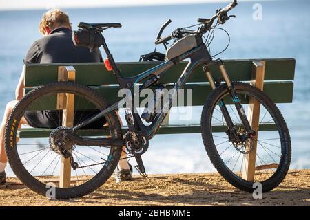 Ein Australier macht eine Pause, wenn er mit seinem mountainbike-Fahrrad von scott an einem Strand in Sydney, NSW, Australien, fährt Stockfoto