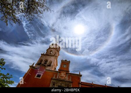 Über der Kathedrale St. Philip Neri in Queretaro, Mexiko, bildet sich ein Sonnenhalo. Stockfoto